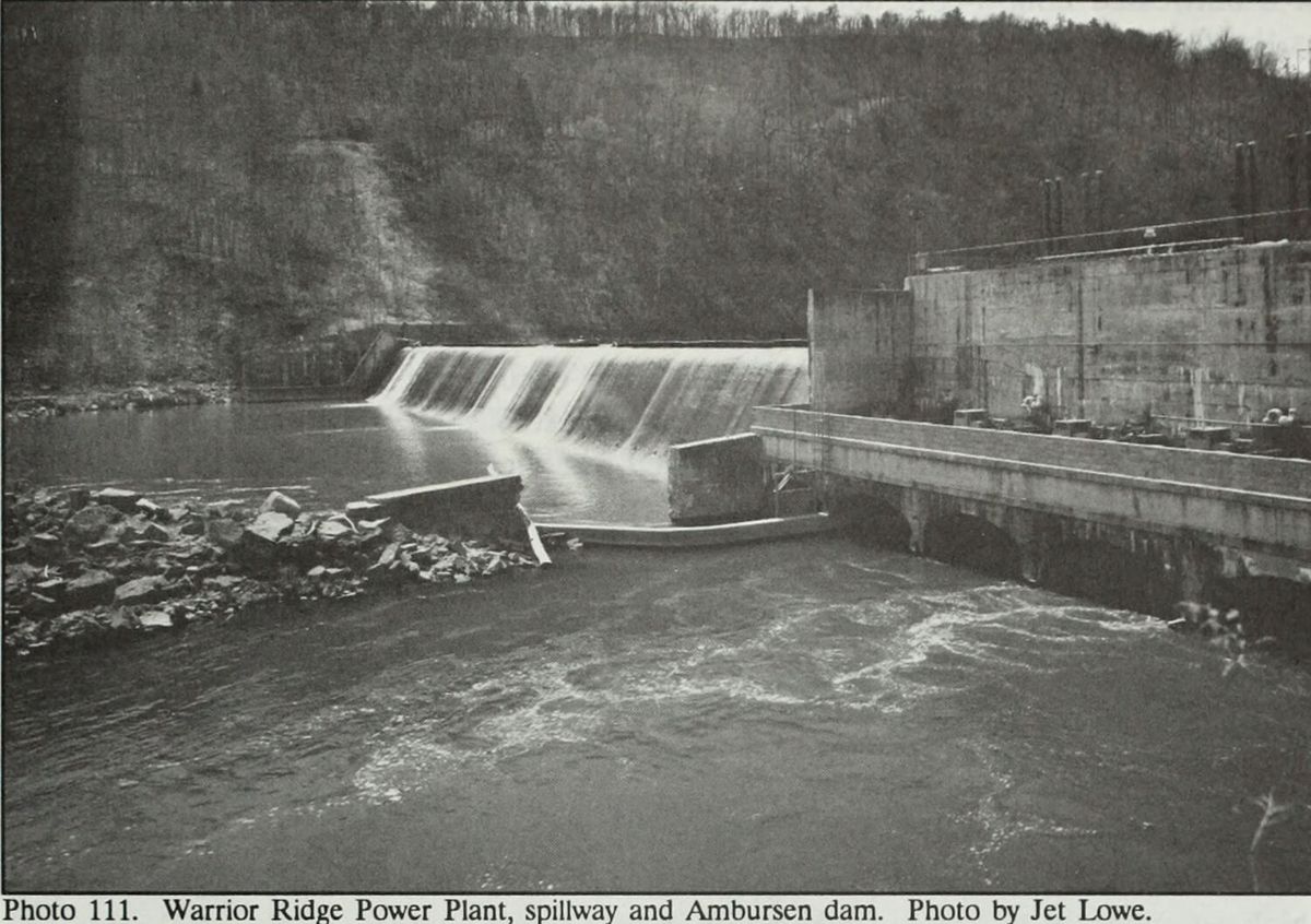 Water going over the spillway at Warrior Ridge, with the Ambursen dam and the power plant to the right.